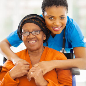 A healthcare professional embracing her patient affectionately around the shoulders and smiling together