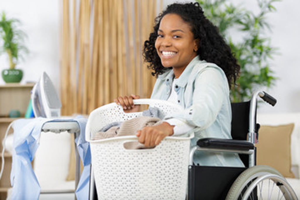 A woman in a wheelchair doing laundry