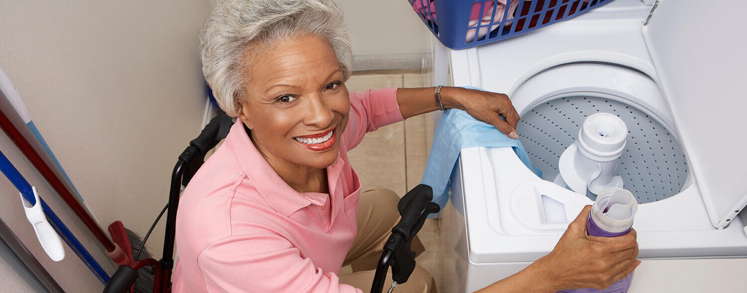 Woman putting clothes in the washer